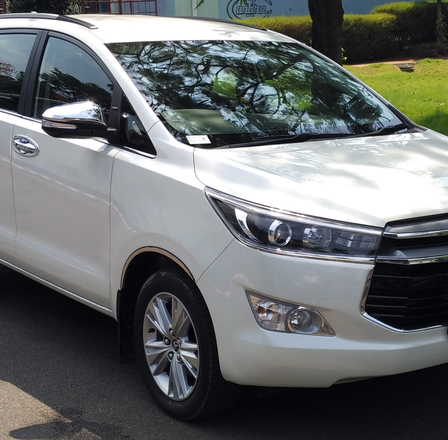 Innova Crysta and Luxury Tour Bus at Temple